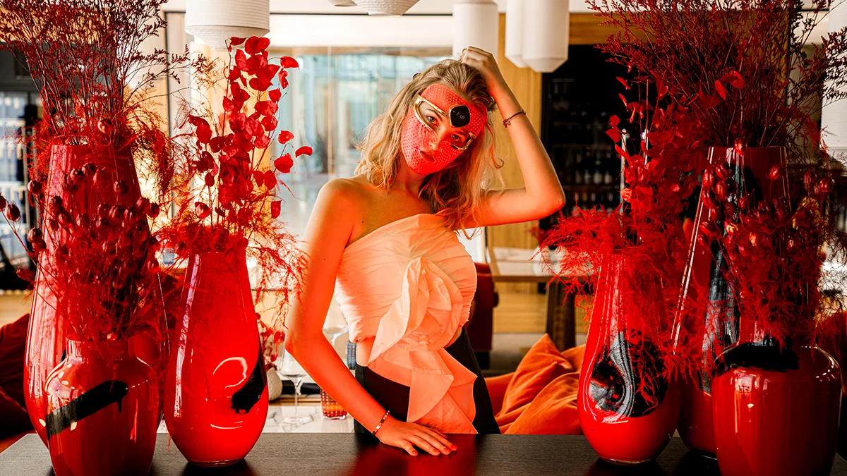 A gorgeous blond girl in a sleveless summer dress doing led light therapy